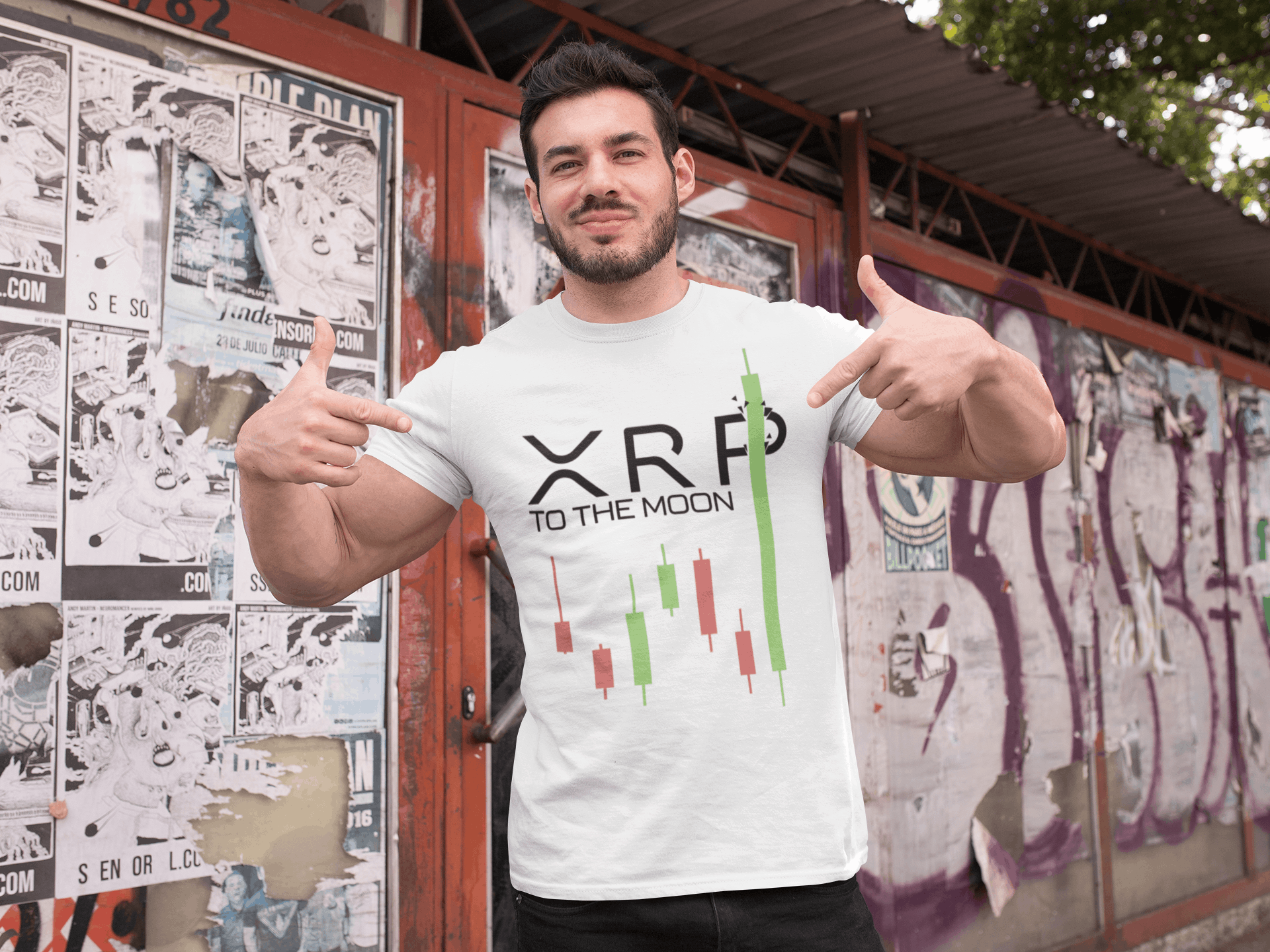 Person wearing a white t-shirt with 'XRP TO THE MOON' design, giving thumbs up in front of a graffiti-covered wall.